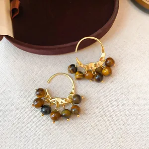 Close-up of retro 18K gold plated hoop earrings with brown tiger eye resin beads
