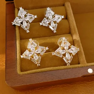 Vista dettagliata di orecchini a clip a forma di trifoglio placcati in oro 18k e argento.
