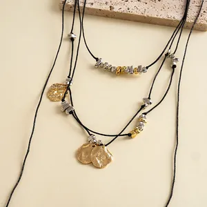 Vista dettagliata di una collana a più strati con pendenti a petalo d'oro rugosi