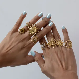 Primer plano de anillos bohemios de acero inoxidable dorado con diseños de sol y luna