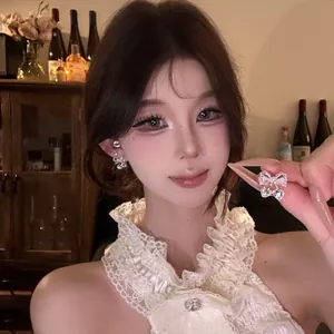 Detailed close-up showing a sparkling zircon bow knot stud earring on an Asian model.