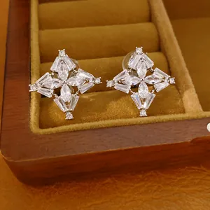 Dettaglio macro di orecchini a clip a trifoglio con zirconi bianchi brillanti