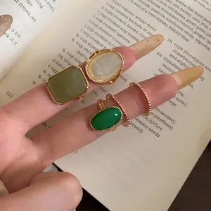 Close-up of vintage resin ring set with square and oval green and white resin stones