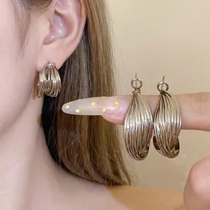 Boucles d'oreilles clous en forme de C argentées au design torsadé multicouche chic.