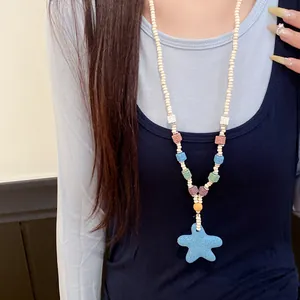 Primer plano de un collar de cuentas de colores con un colgante de estrella de mar azul