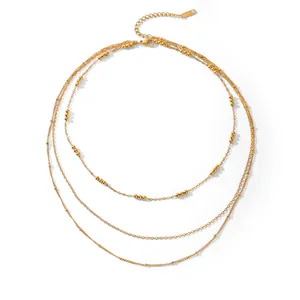 Detail shot of a layered three-row gold bead necklace with elegant French vintage style