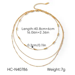 Macro view of a gold-plated triple-layered necklace showing dimensions and bead size