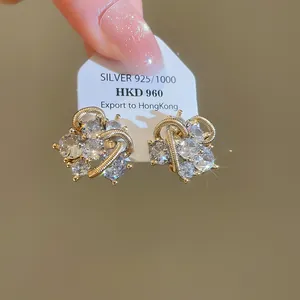 Nahaufnahme funkelnder geometrischer Zirkonia-Ohrstecker mit 925er Silbernadel.