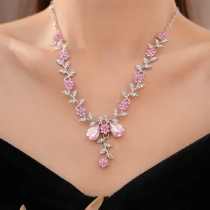 Nahaufnahme einer rosa-weißen Kristall-Blumenkette mit filigranen Blattdetails.