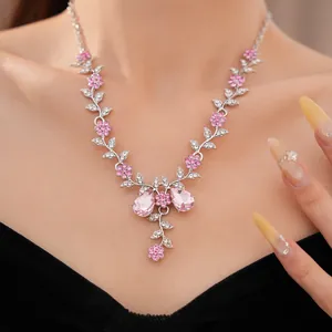 Nahaufnahme einer eleganten rosa Strass-Halskette mit Blumen- und Blattmotiv am Model