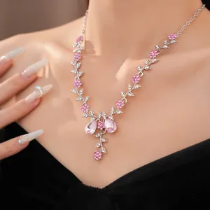 Elegante Halskette mit rosa Strassblumen und Blaettern in der Nahaufnahme am Hals