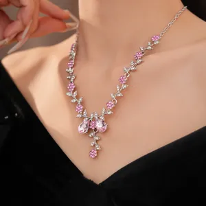 Detailaufnahme einer eleganten Halskette mit rosa Kristallen und Blumen-Blatt-Mustern