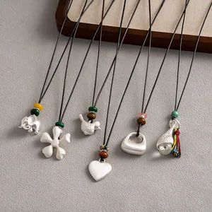 Vue détaillée de divers colliers de style ethnique avec pendentifs cœur et éléphant
