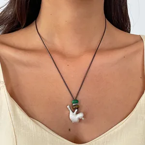 Vue détaillée d'un collier pendentif oiseau en céramique ethnique avec cordon en cuir