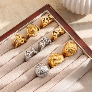 Set of 18K gold plated stainless steel rings with hammered texture and letter motifs