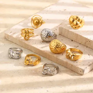 Collection of minimalist stainless steel rings with unique beaten textures and gold finish