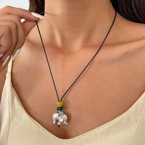 Collier style ethnique avec pendentif éléphant argenté sur cordon porté par modèle
