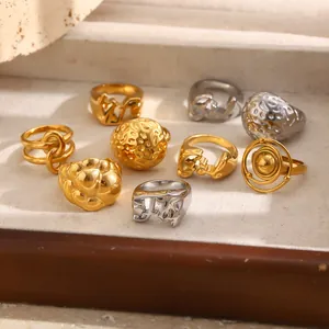 Assorted gold and silver hammered titanium steel rings with geometric and letter designs