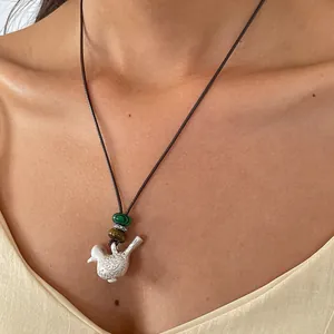Vue détaillée d'un collier ethnique avec pendentif oiseau sur cordon en cuir