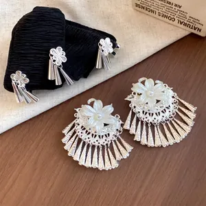 Gedetailleerd overzicht van elegante parelbloem oorbellen en kwastje haarclip set