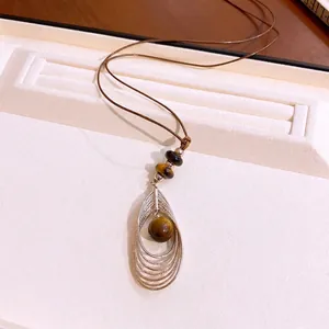 Elegante halsketting met tijgeroog steen hanger, gelaagd ontwerp en bruin koordje