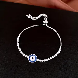 Vue détaillée d'un bracelet bolo mauvais œil argenté avec des zircons bleus et blancs.