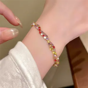 Vue détaillée d'un bracelet doré torsadé orné de zircons colorés étincelants