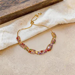 Vue détaillée d'un bracelet réglable avec zircons colorés et chaîne dorée