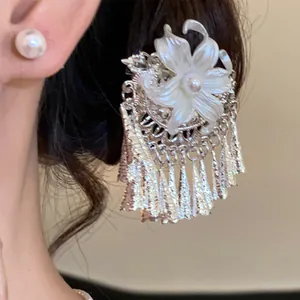 Detailopname van haarklem met parelbloem en elegante zilveren kwastjes