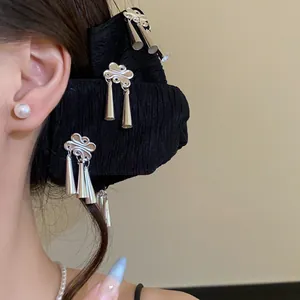 Detail van zwarte haarclip met zilveren wolkkwastjes in moderne Chinese stijl ornamenten.