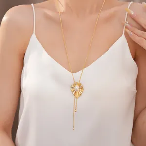 Detail view of an 18k gold plated sunburst pearl slider necklace worn by a model