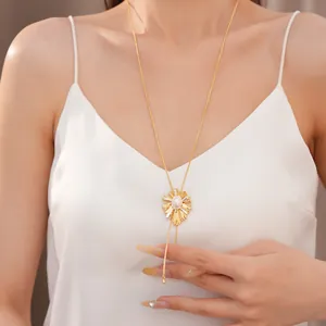 Close-up detail of an elegant 18k gold-plated pearl sunburst pull-through necklace