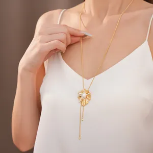 Model wearing adjustable 18k gold plated sunburst necklace with pearl inlay detail