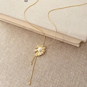 Detail of 18k gold plated sunburst necklace with pearl and adjustable pull chain.