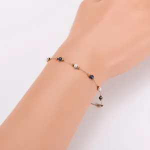 Detailaufnahme eines zarten 18k vergoldeten Armbands mit blau-weißen Marmorperlen