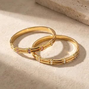 Detail of zircon inlaid stainless steel gold bangles with elegant bamboo texture.