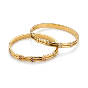 Detailed view of gold stainless steel geometric bangles with inlaid zircons