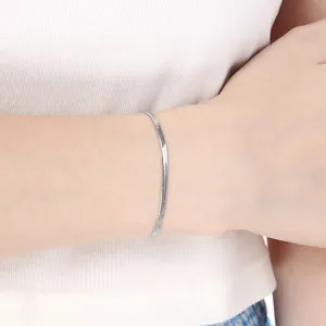 Nahaufnahme eines minimalistischen silbernen Edelstahl-Gliederkettenarmbands am Handgelenk.