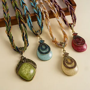 Detailweergave van retro druppelhangers met kleurrijke gevlochten koorden en stenen