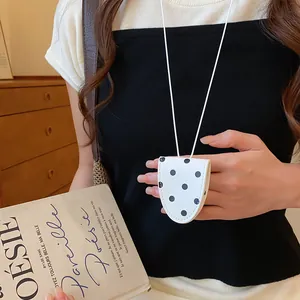 Gedetailleerd overzicht van retro halsketting met brillenclip en stippen op een model