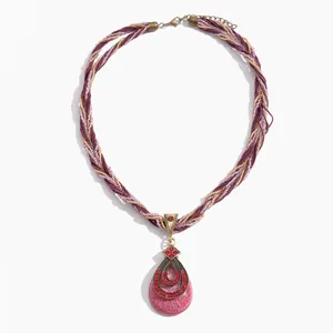 Vintage boho ketting met roze druppelvormige hanger en rode kristalaccenten.