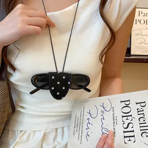 Detail van een retro polkadot zonnebrilclip-ketting gedragen op een modieuze witte top