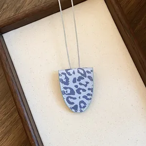 Macro-weergave van de brilhouderketting met luipaardprint en zichtbare stiksels.