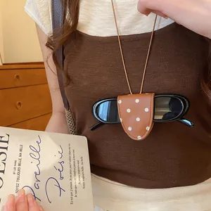Gedetailleerd overzicht van een retro brilclip ketting met stippen en een zonnebril