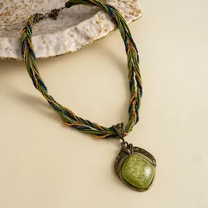 Detailopname van vintage boho-ketting met groene hars hanger en gevlochten koord