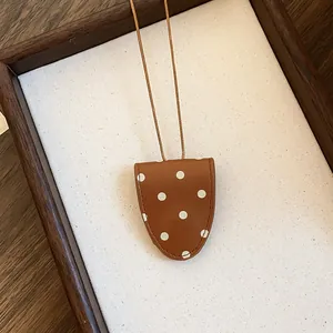 Detail van een retro bruine brillenhouder ketting met stippen op een canvas achtergrond.