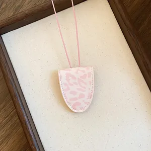 Detail van de roze lederen brillenhouder ketting met luipaardprint op stof