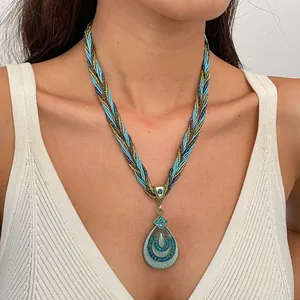 Detailopname van een vintage druppelvormige hanger met blauwe marmerhars en glanzende strass