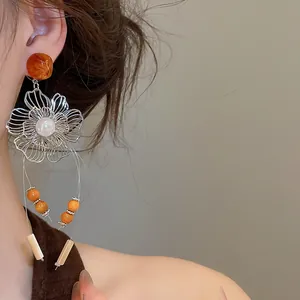 Detail view of vintage hollow flower tassel earring with pearl and resin beads for women