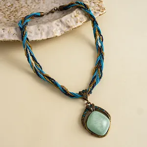Gedetailleerde weergave van een gevlochten ketting in vintage stijl met een turquoise hanger